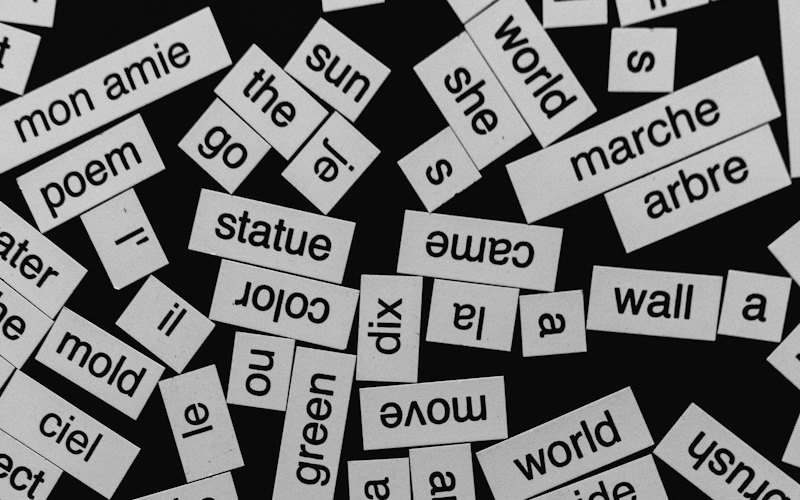 Printed English and French word cards scattered across a black table