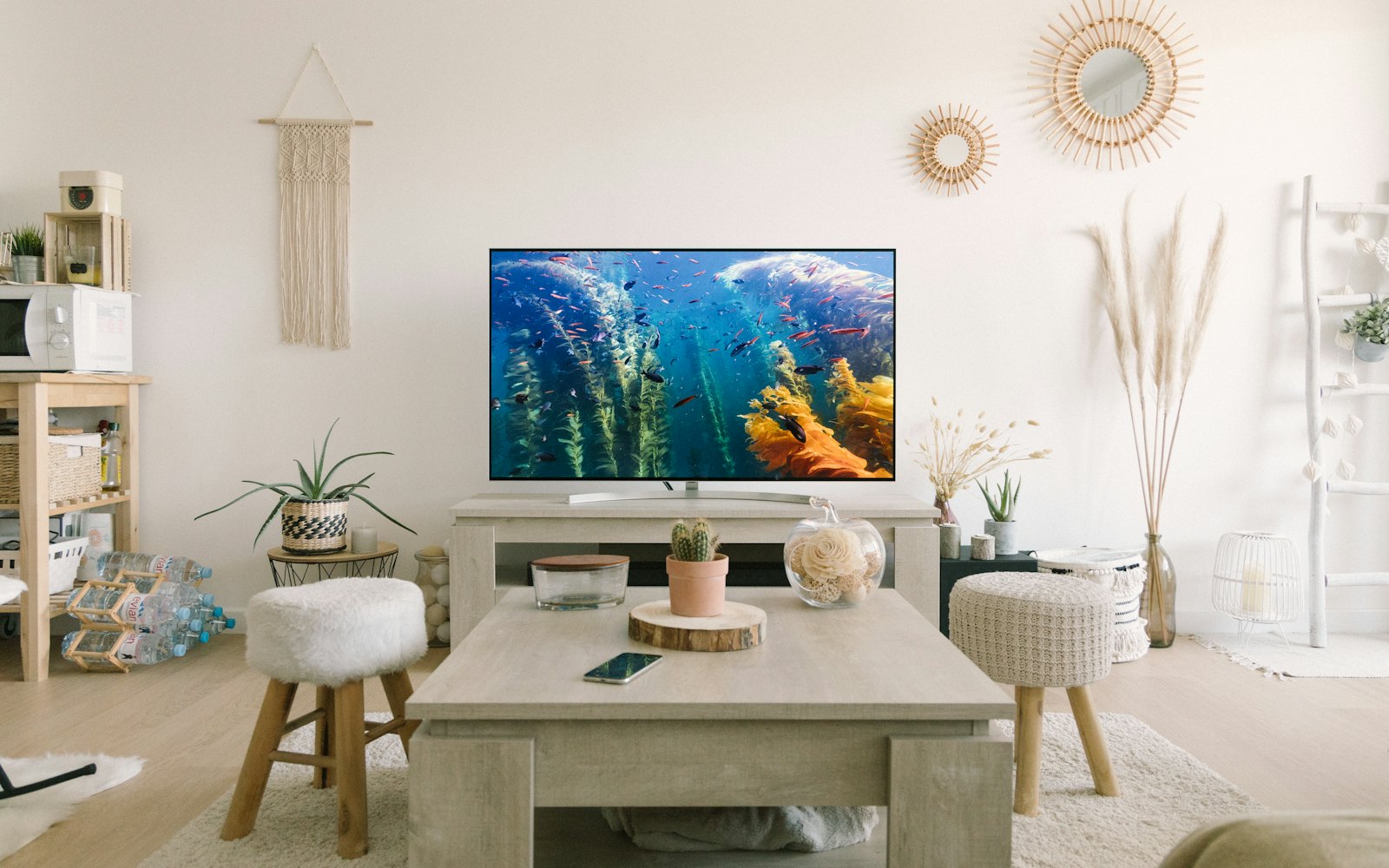A bright living room with a big TV above a low wooden console